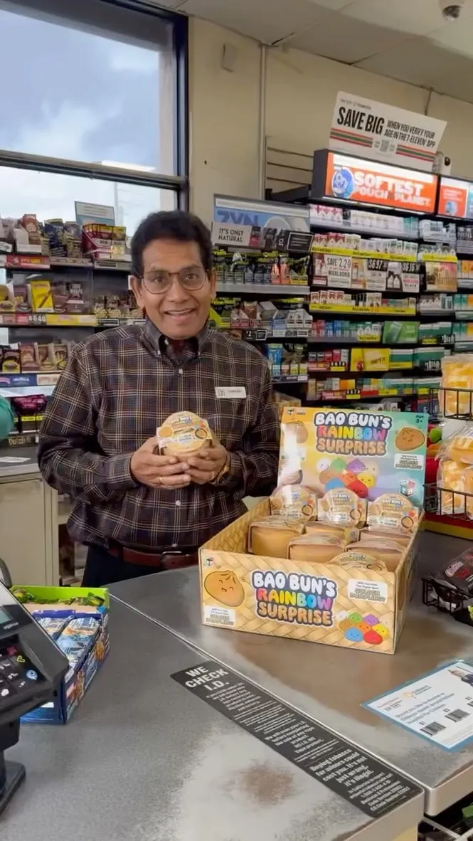 A store owner with a Bao Bun's counter display